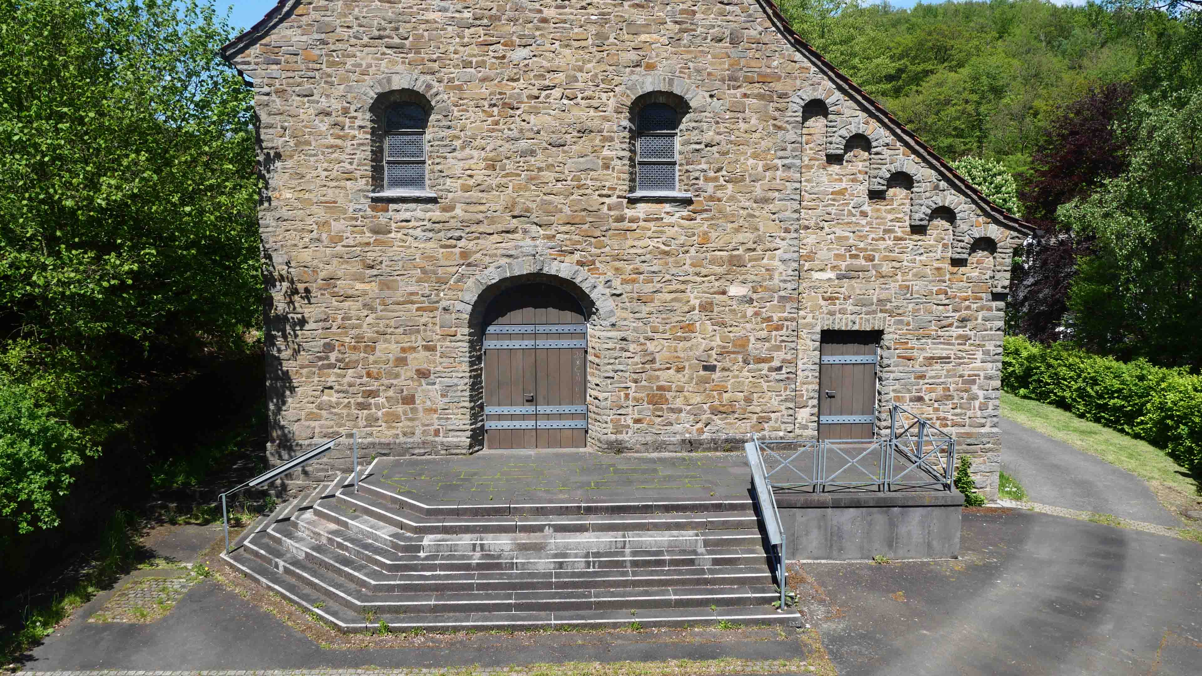 Morsbach-Ellingen: Stilvolle, kleine Bruchsteinkirche, Treppenaufgang zum Haupt- und Nebeneingang