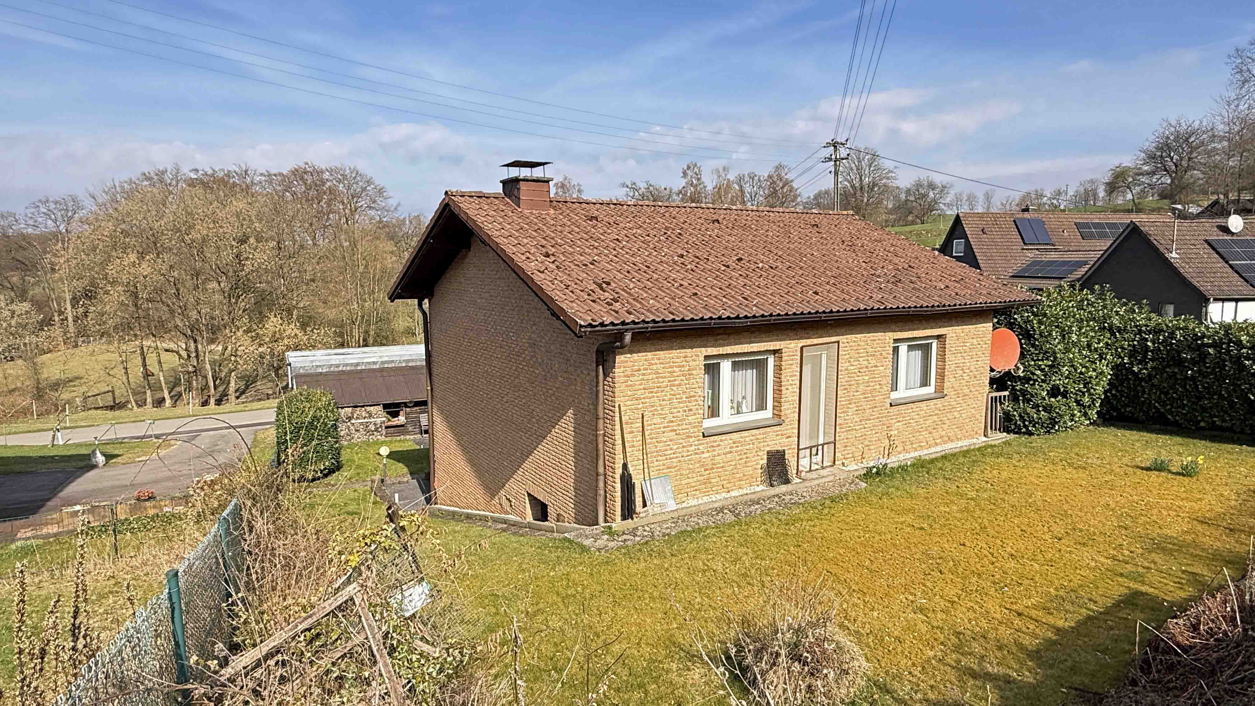 Reichshof-Buchen: Mit Wohnmobil-Carport und hundegerecht eingezäuntem Grundstück, Hausrück-/ Südseite mit Tür zur ebener Rasenfläche