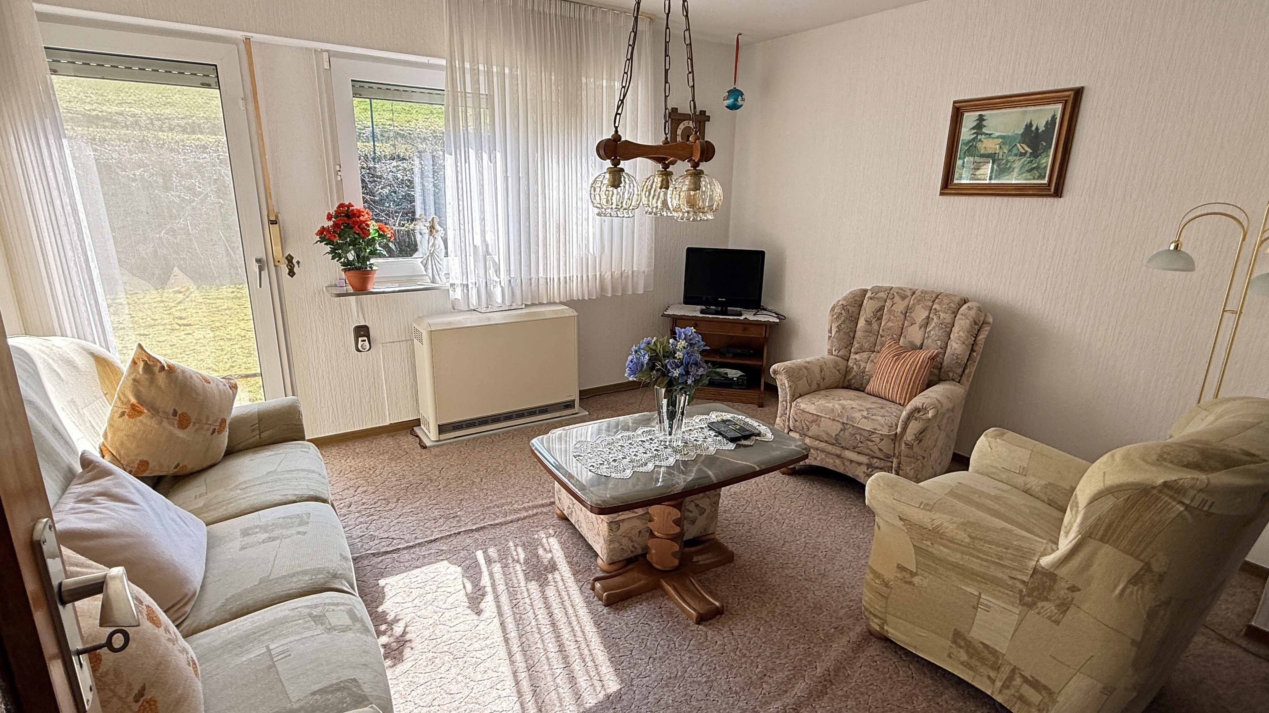 Reichshof-Buchen: Mit Wohnmobil-Carport und hundegerecht eingezäuntem Grundstück, Wohnzimmer mit Ausgang zum Garten