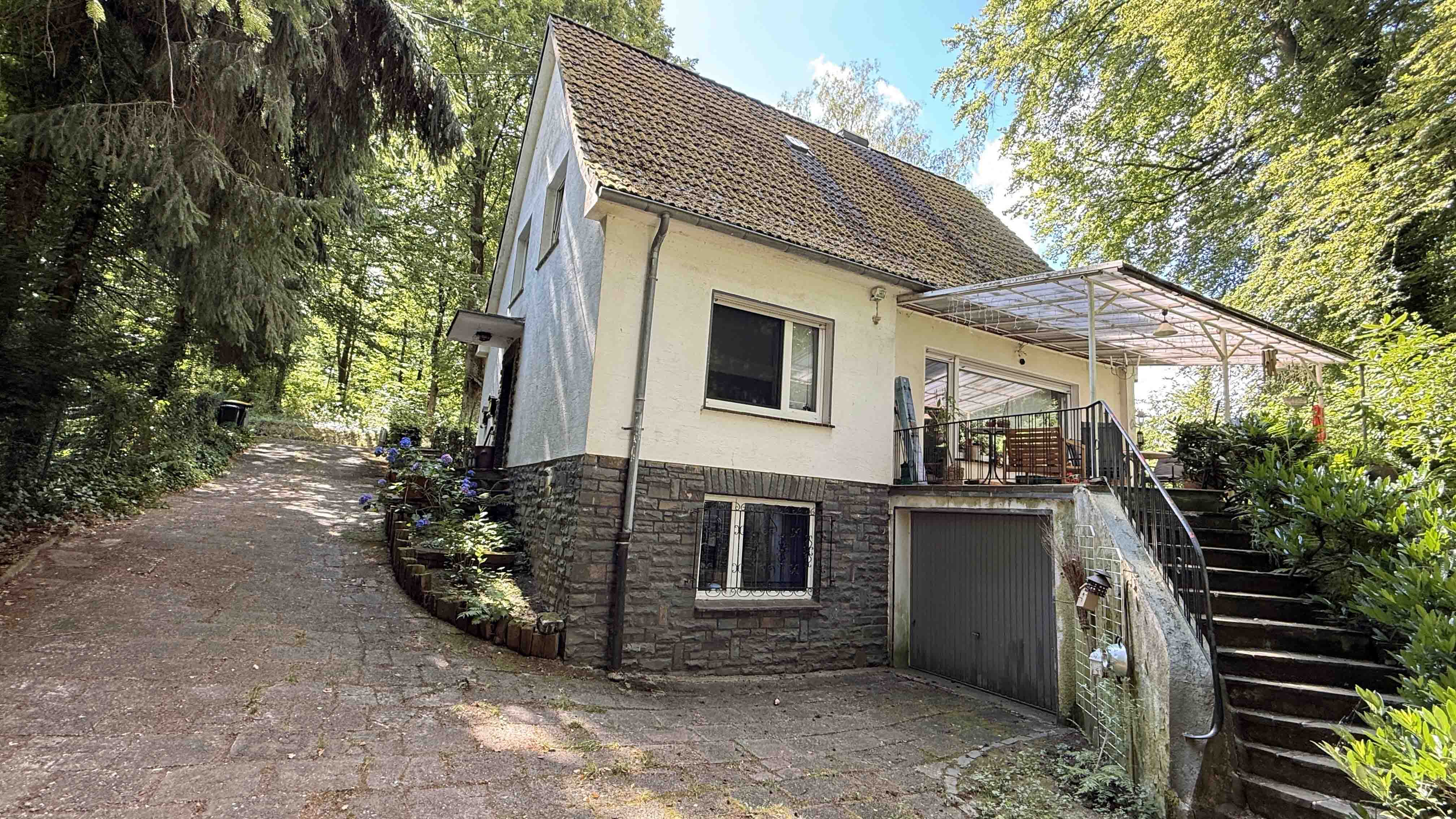 Reichshof-Sterzenbach: Ein- bis Zweifamilienhaus mit zwei Fischteichen, Hausrückseite mit großer überdachter Terrasse